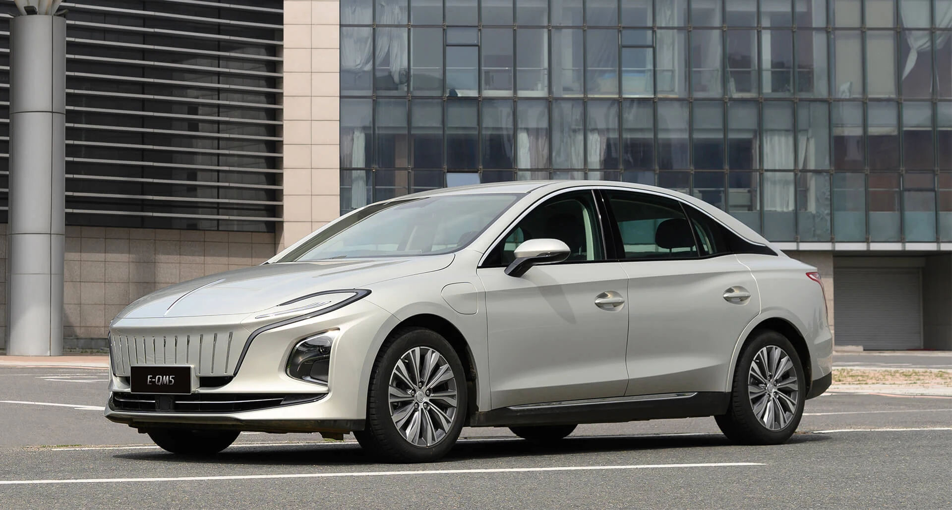 Silver Hongqi E-QM5 in front of a modern building, official model reference image